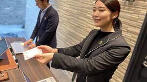 A reception desk with a laptop, a notepad, and a pen. - Randor Residential Hotel Sapporo Suites (Sapporo)