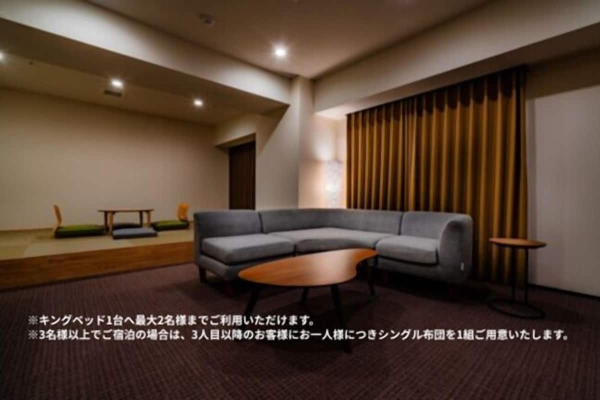 A modern living room with a grey sectional sofa, a wooden coffee table, and a small side table.