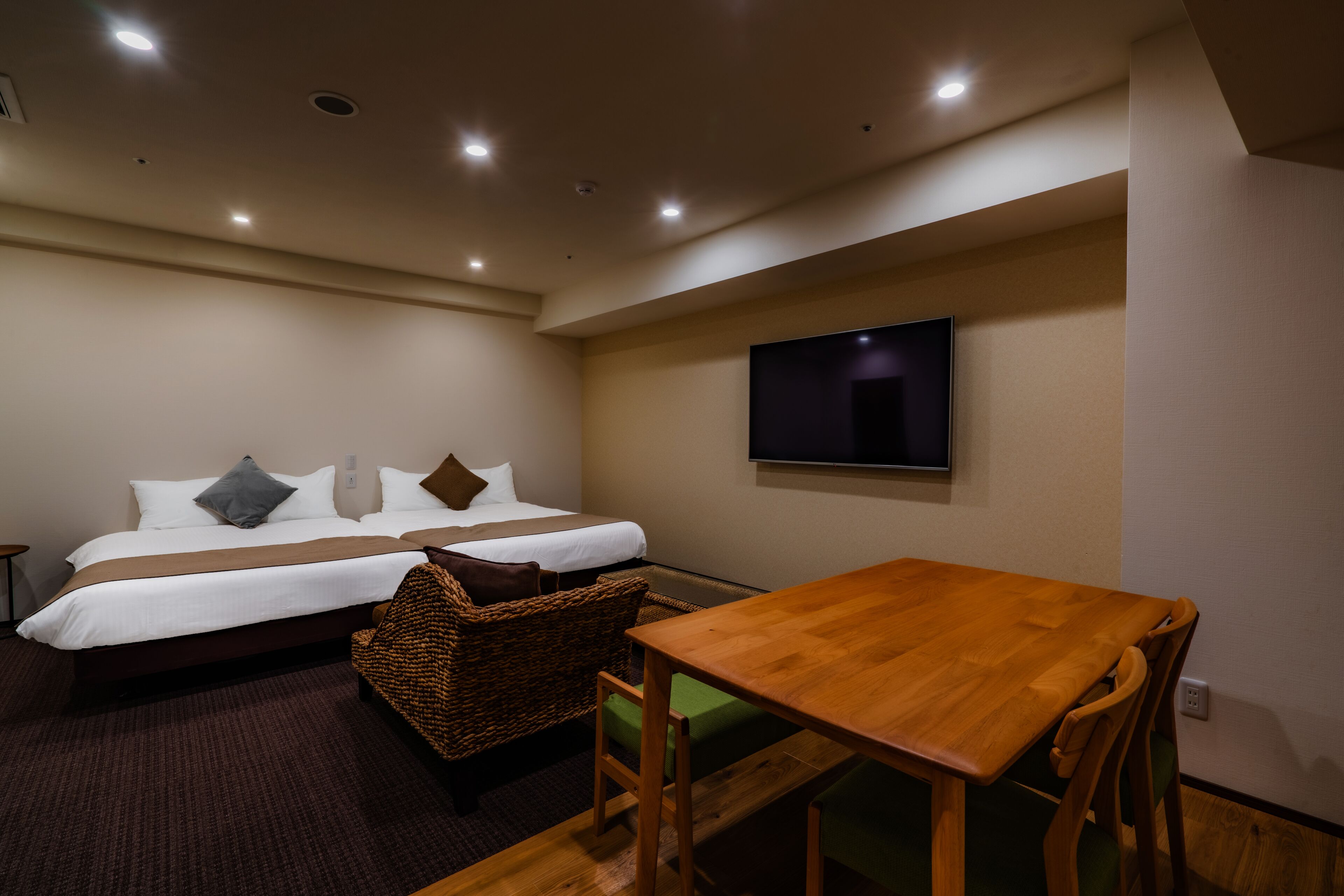 A hotel room with a bed, a wooden table, and a television.