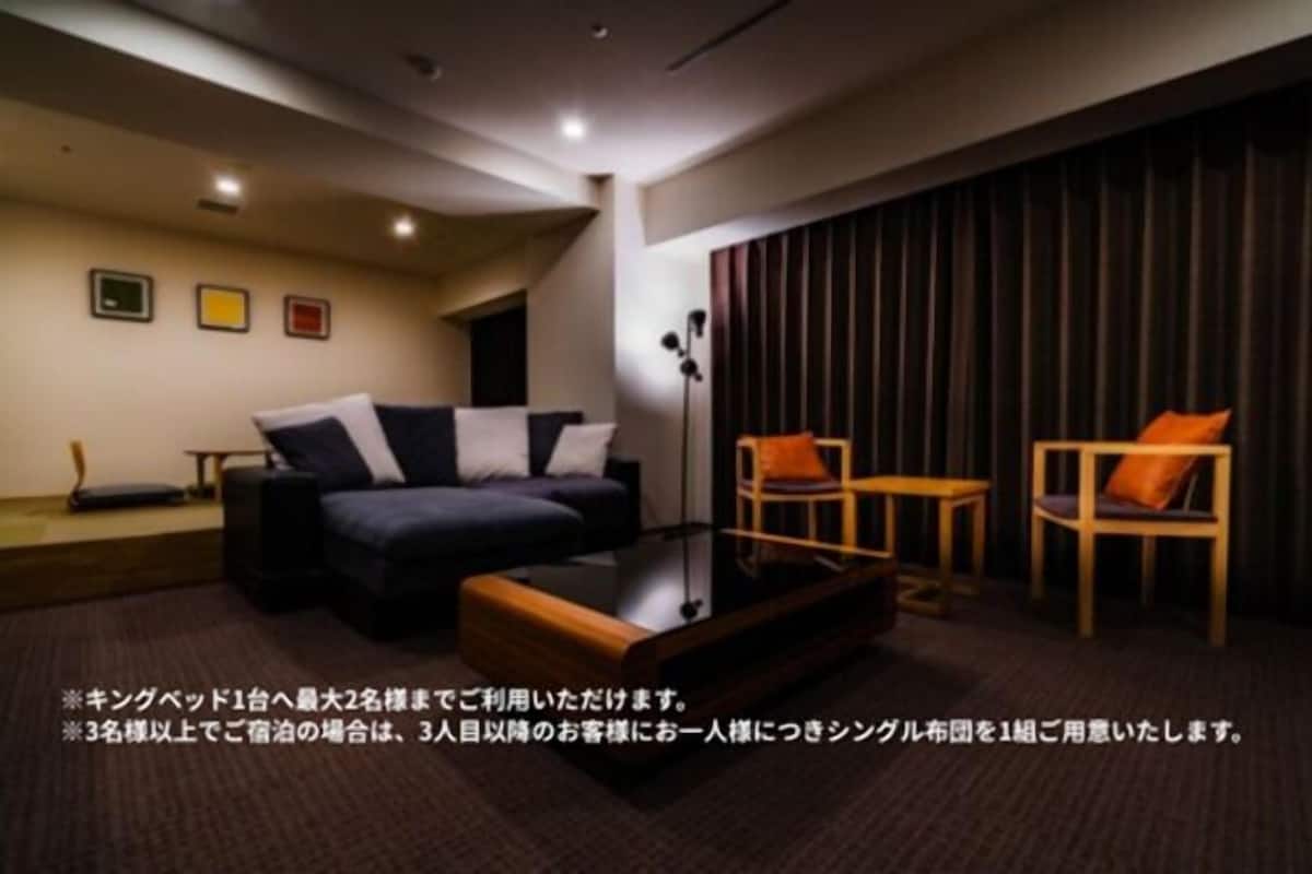 A modern living room with a sofa, two chairs, a coffee table, and a floor lamp.