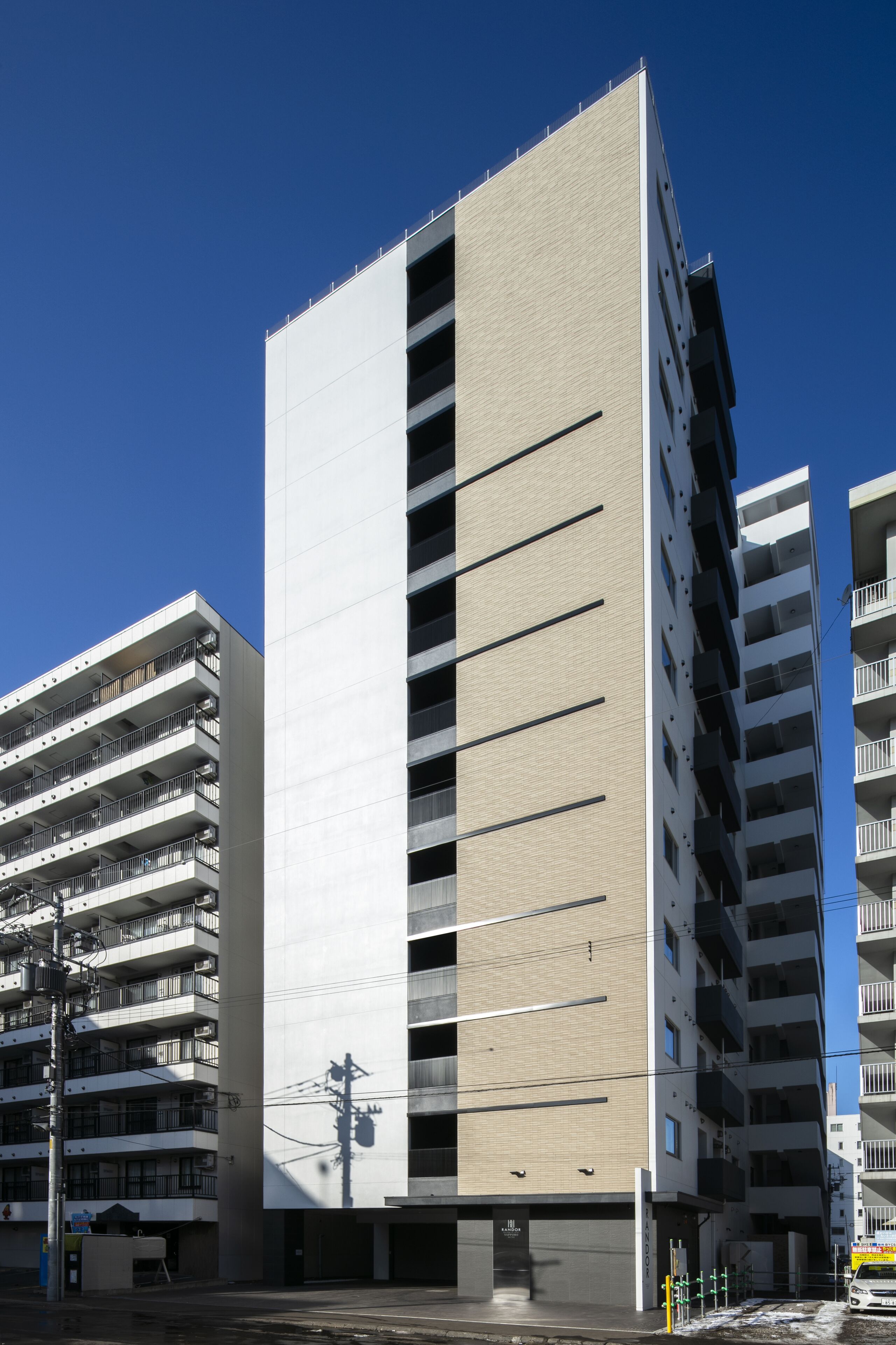 A multi-story building with a modern architectural design, featuring balconies and a flat facade.