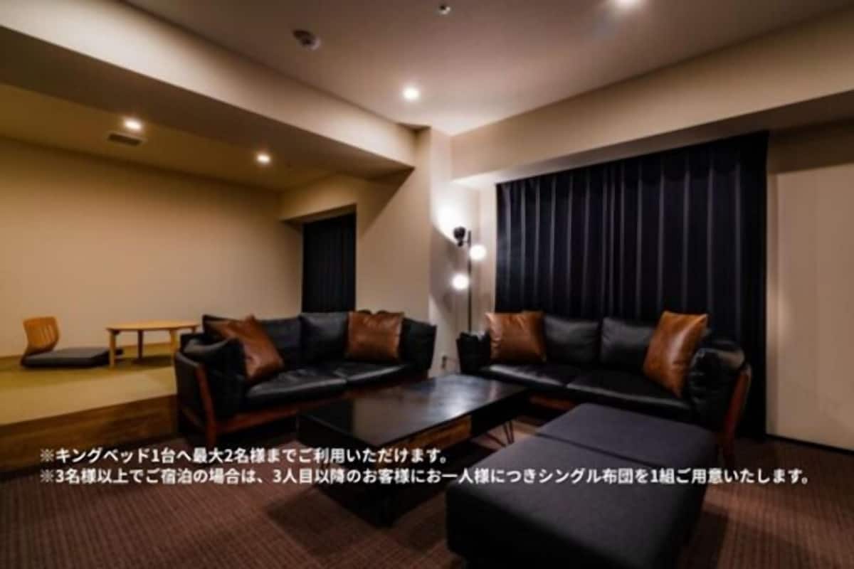 A modern living room with a sofa set, a coffee table, and a small table with chairs.