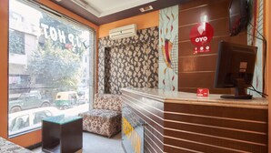 Un área de recepción con mostrador, sofá y pared con diseño.