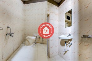 A bathroom with a toilet, bidet, and sink, all with a bird pattern on the walls. - OYO 24838 Hotel Neelam (Amravati)