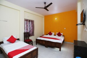 A hotel room with two beds, a ceiling fan, a TV, and a window with curtains. - OYO Flagship 22406 Shree Shree Guest House (Varanasi)