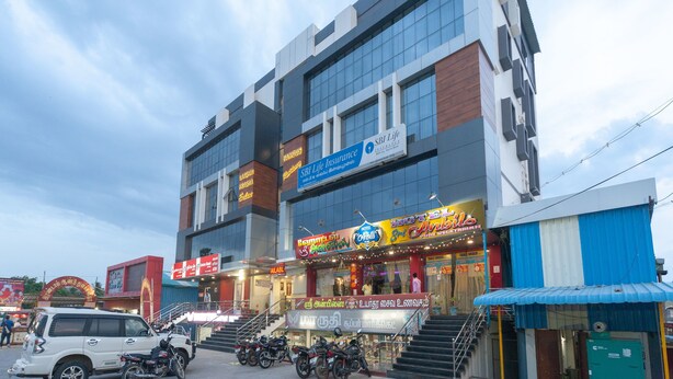 A multi-story building with a sign for SBI Life Insurance and a hotel named Hotel Ambars. - OYO 16595 Famous Residency (Tiruchirappalli)