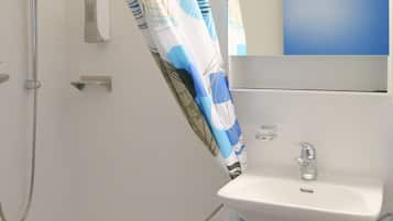 Un baño con bañera, ducha, lavamanos y espejo.