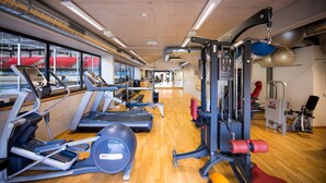 A gym with treadmills, elliptical machines, and weightlifting equipment. - Hotel le Palladium (Champery)