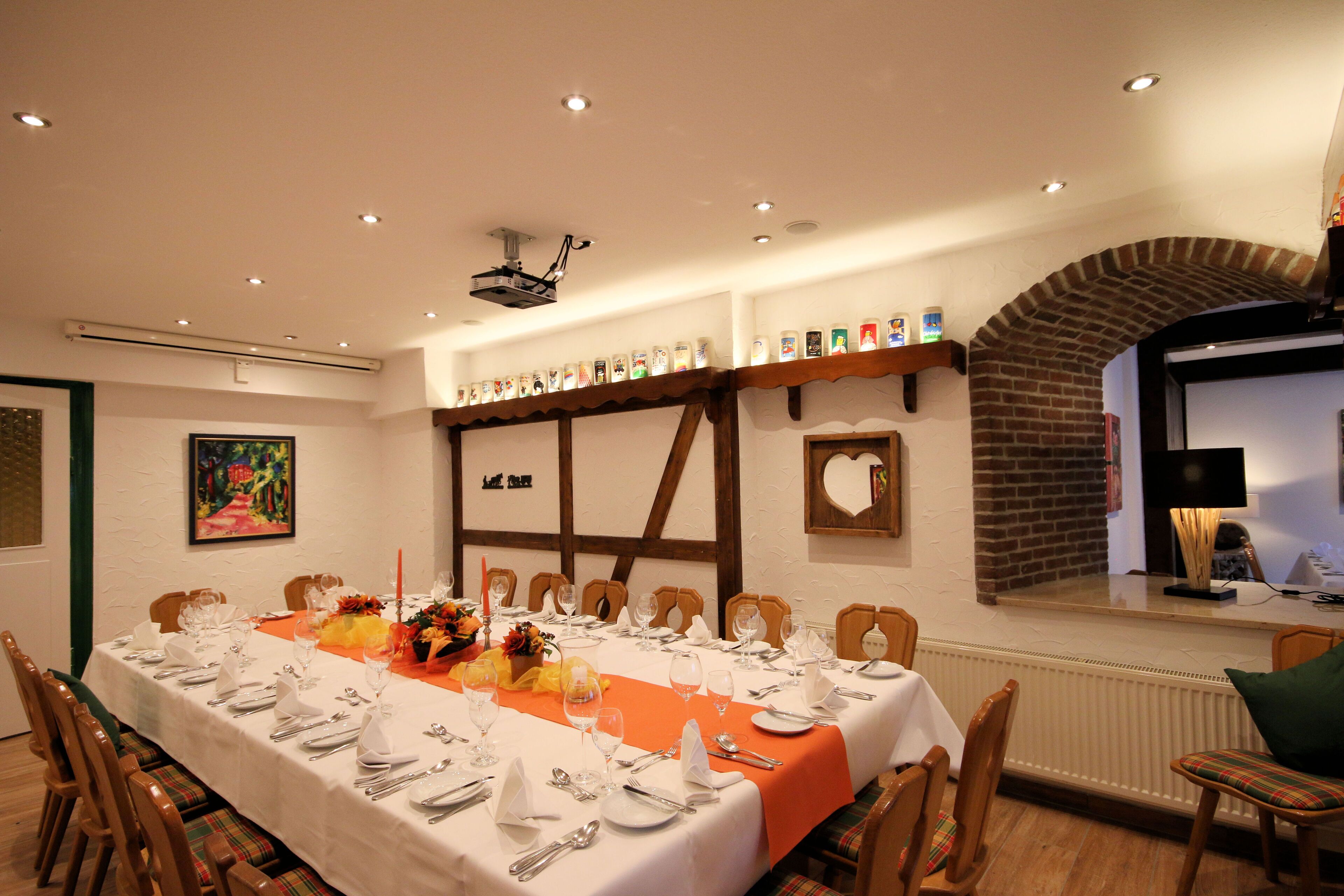 A dining area with a long table set for a meal, surrounded by wooden chairs.