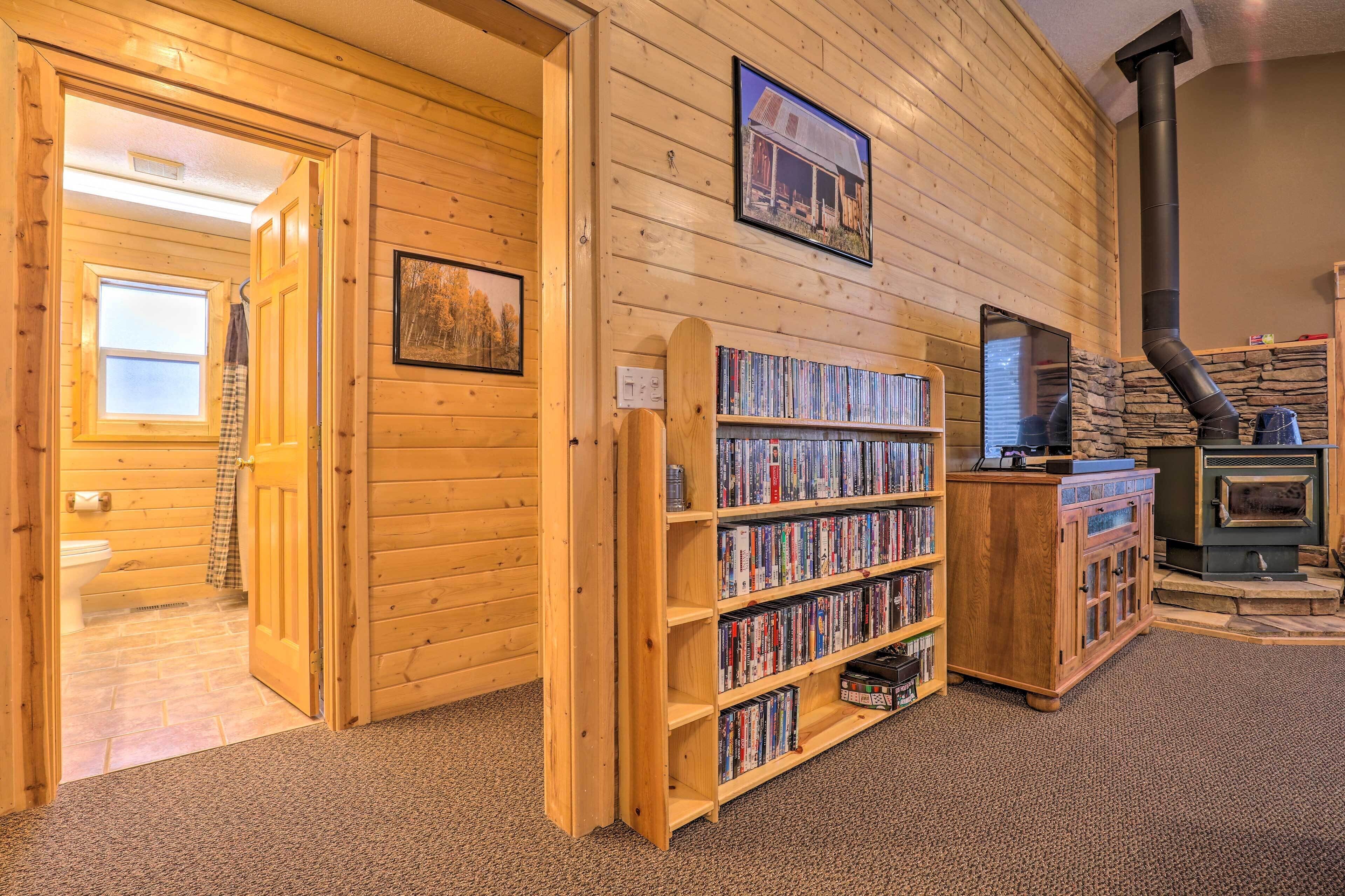 Un intérieur en bois avec une cheminée, des étagères et un mur en pierre.