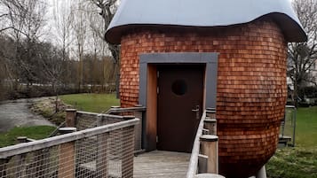 A wooden dome structure with a door and a wooden walkway leading to it.