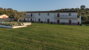 A two-story building with a flat roof, red doors, and a balcony on the upper floor. - Agriturismo di Serragiumenta (Altomonte)