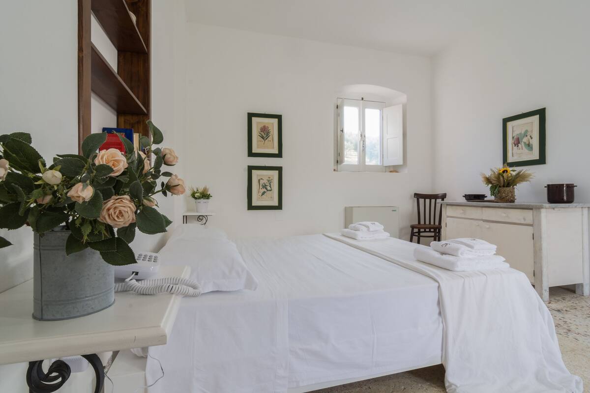 Une chambre bien rangée, avec un lit, un bureau, une chaise et une fenêtre.
