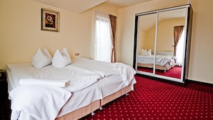 A double bed with white linens, a red carpeted floor, a large mirror, and a framed picture on the wall. - Pensiunea Schwartz (Cluj-Napoca)