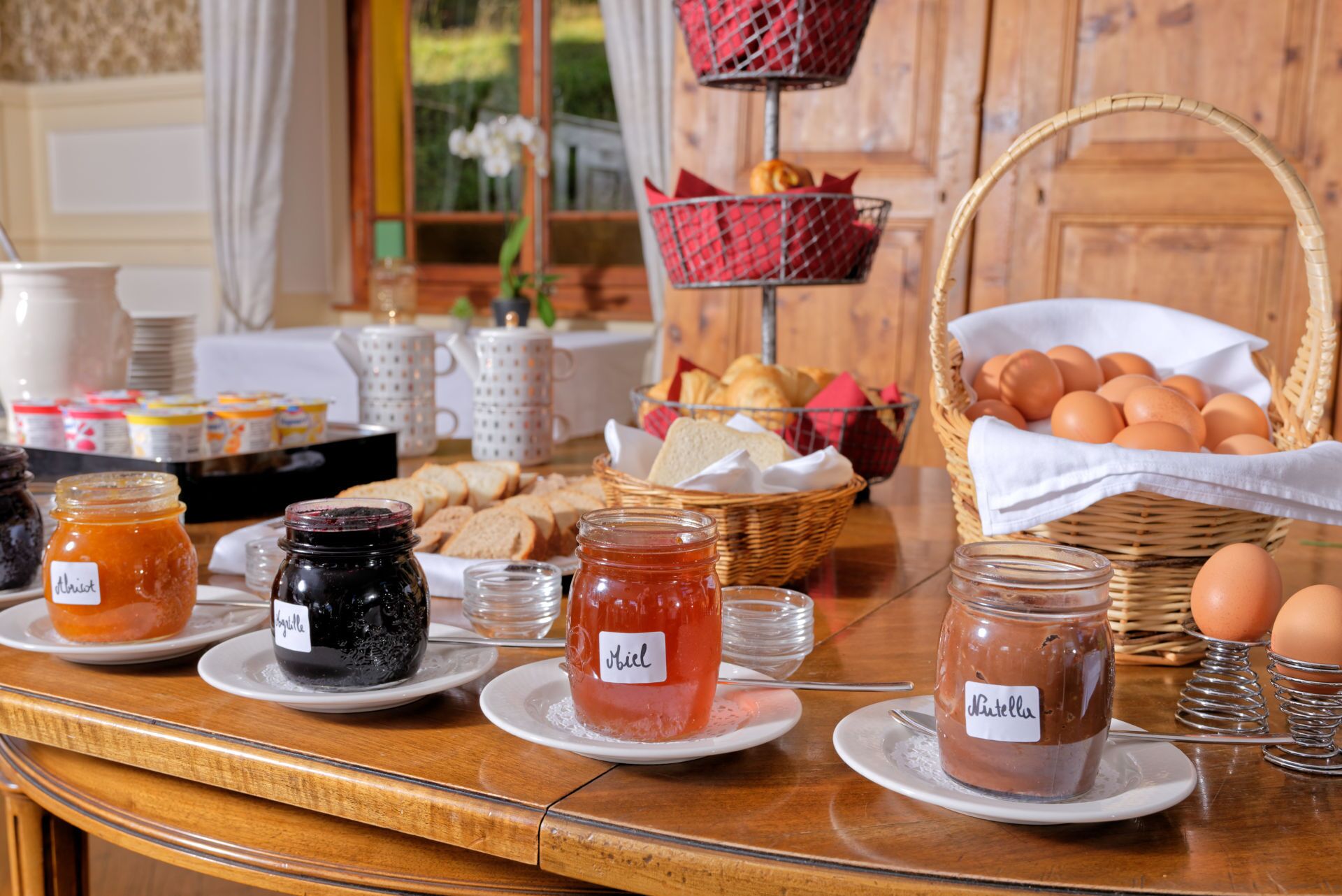Un buffet de petit-déjeuner proposant une variété de confitures, de pains, d’œufs et de viennoiseries.