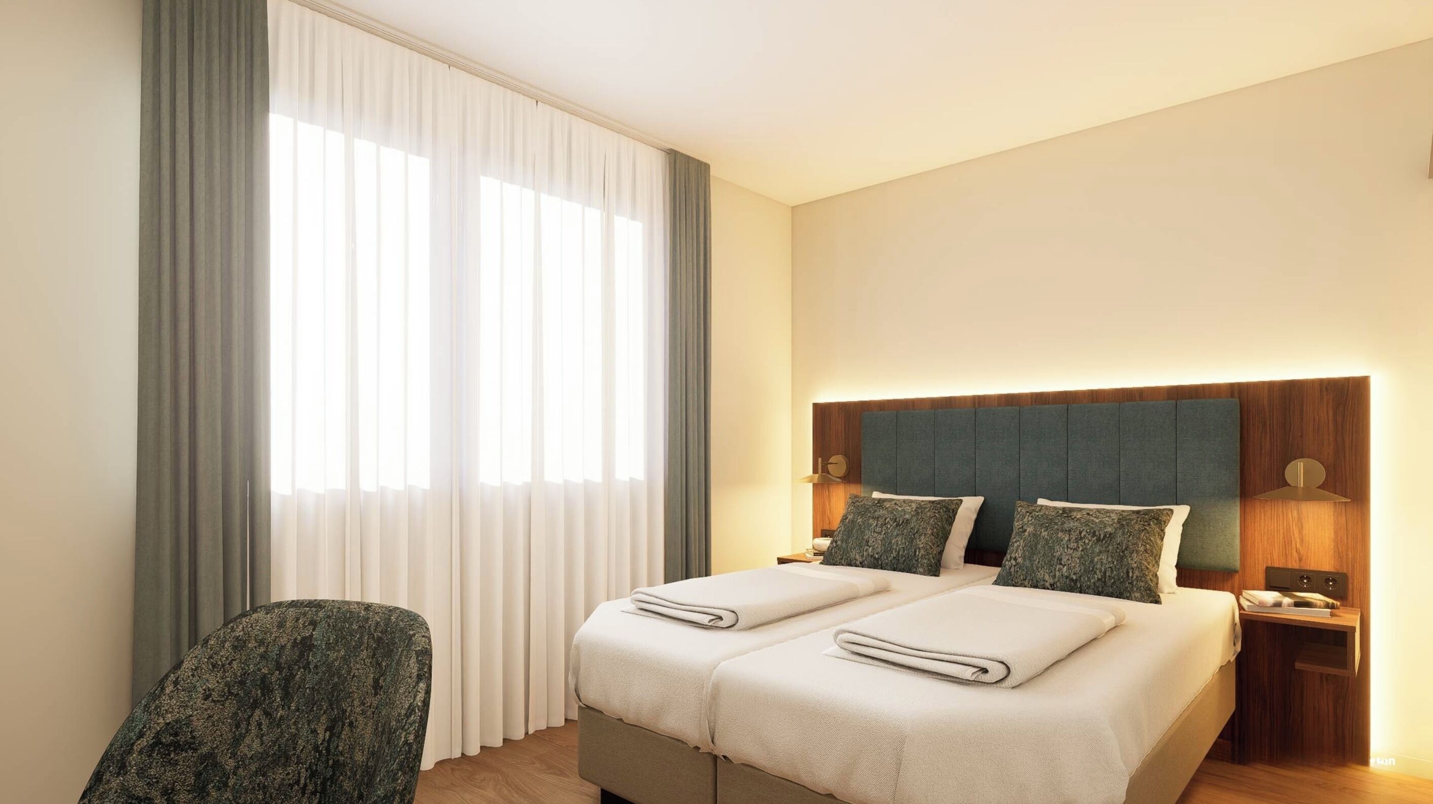 Habitación de hotel con cama, una silla, mesita de noche y ventana con cortinas.