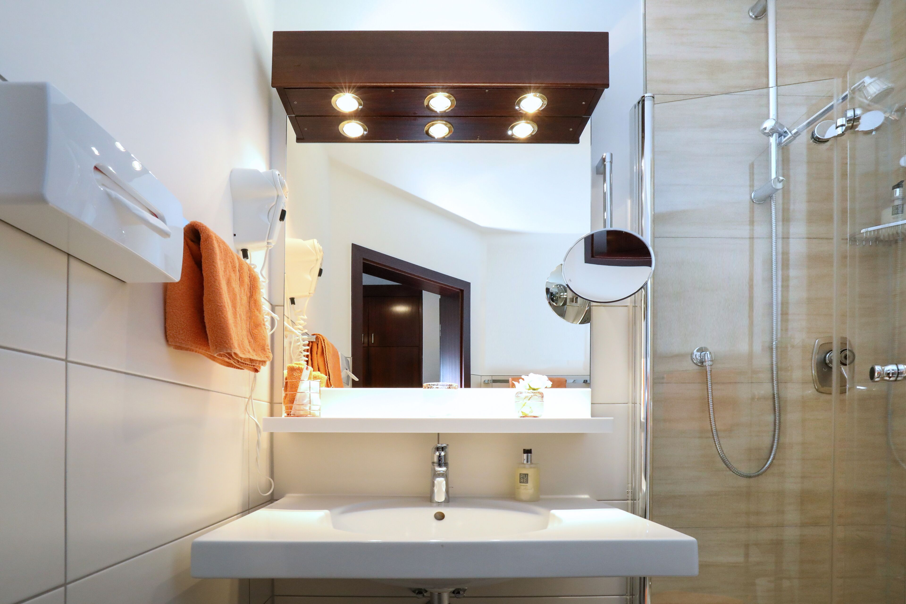 Ein modernes Badezimmer mit Waschbecken, Spiegel und Dusche.