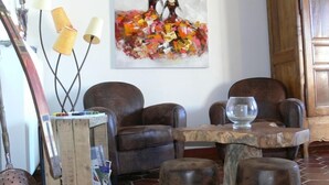 Una sala de estar con dos sillones de cuero, una mesa de centro de madera y un cuadro en la pared.