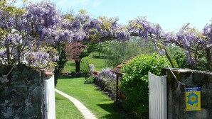 Un sendero de jardín que conduce a un edificio con un letrero que indica que es un hotel.