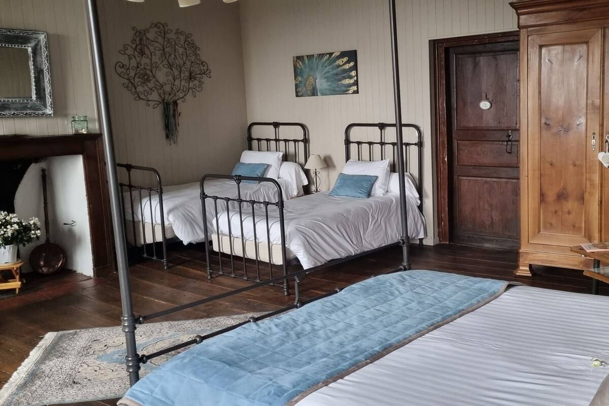 Ein Schlafzimmer mit zwei Metallbetten, einem Holzschrank, einem großen Spiegel und einem Wanddekor.