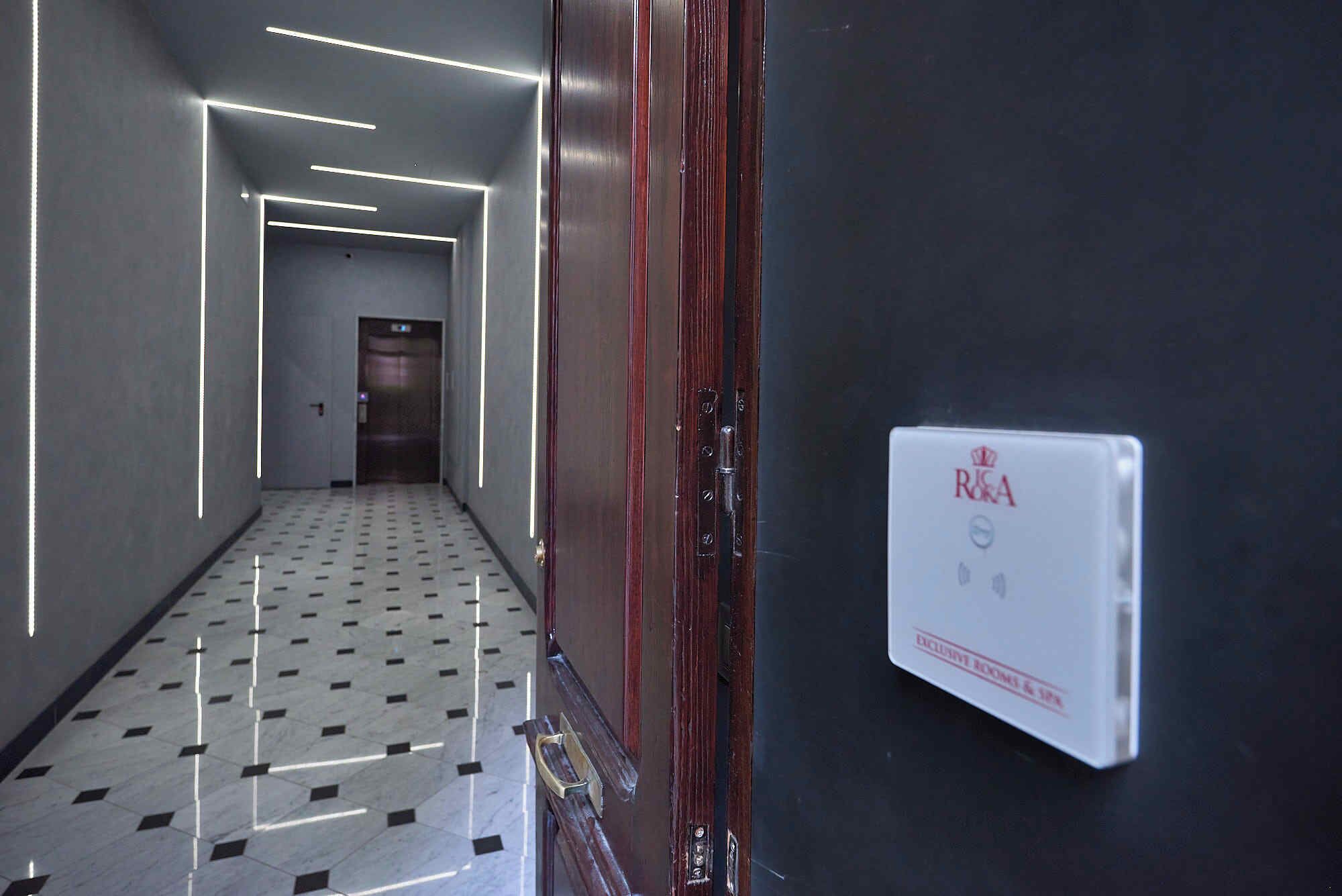 A hallway with a check-in counter, a reception area, and a door with a security card reader.