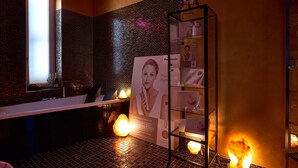 A modern bathroom with a glass shower enclosure, a visible bottle of champagne, and a display of Panasonic products.