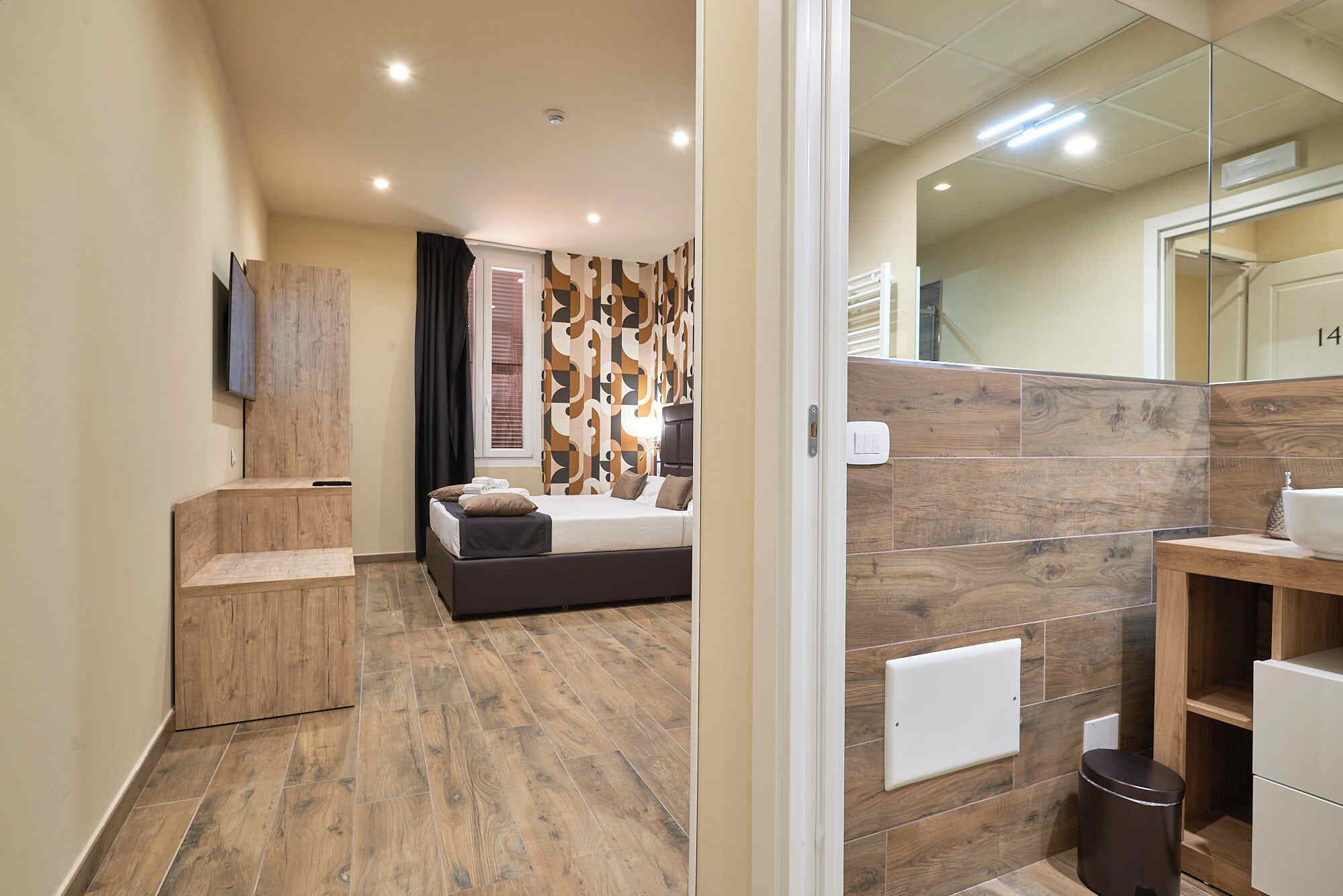 A modern bedroom with a wooden floor, a bed with pillows, a bedside table, and a mirror.