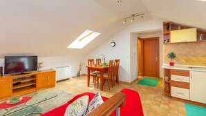 A modern apartment with a dining area, kitchen, and a TV. - Apartments Mondo (Dubrovnik)