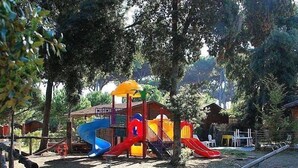 Ein Spielplatz mit mehreren Rutschen und einer kleinen Gebäudestruktur.