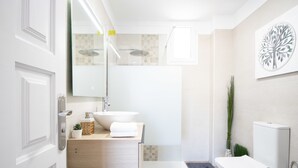 Ein modernes Badezimmer mit einem großen Waschbecken, einer Toilette und einer Dusche.