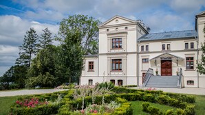 Ein großes, mehrgeschossiges Gebäude mit einer symmetrischen Fassade, einer zentralen Treppe und einem repräsentativen Eingang.