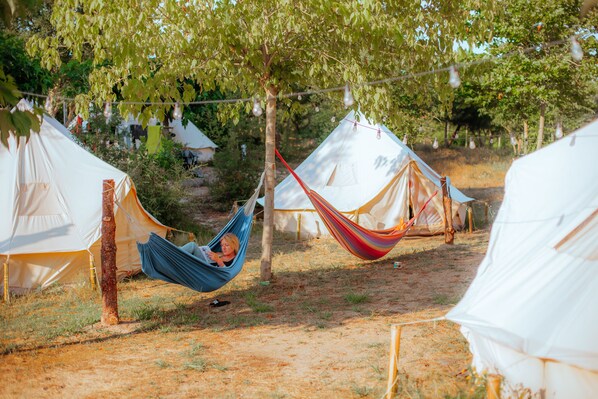A campsite with multiple tents, a hammock, and string lights. - Star Surf Camps (Valdaliga)