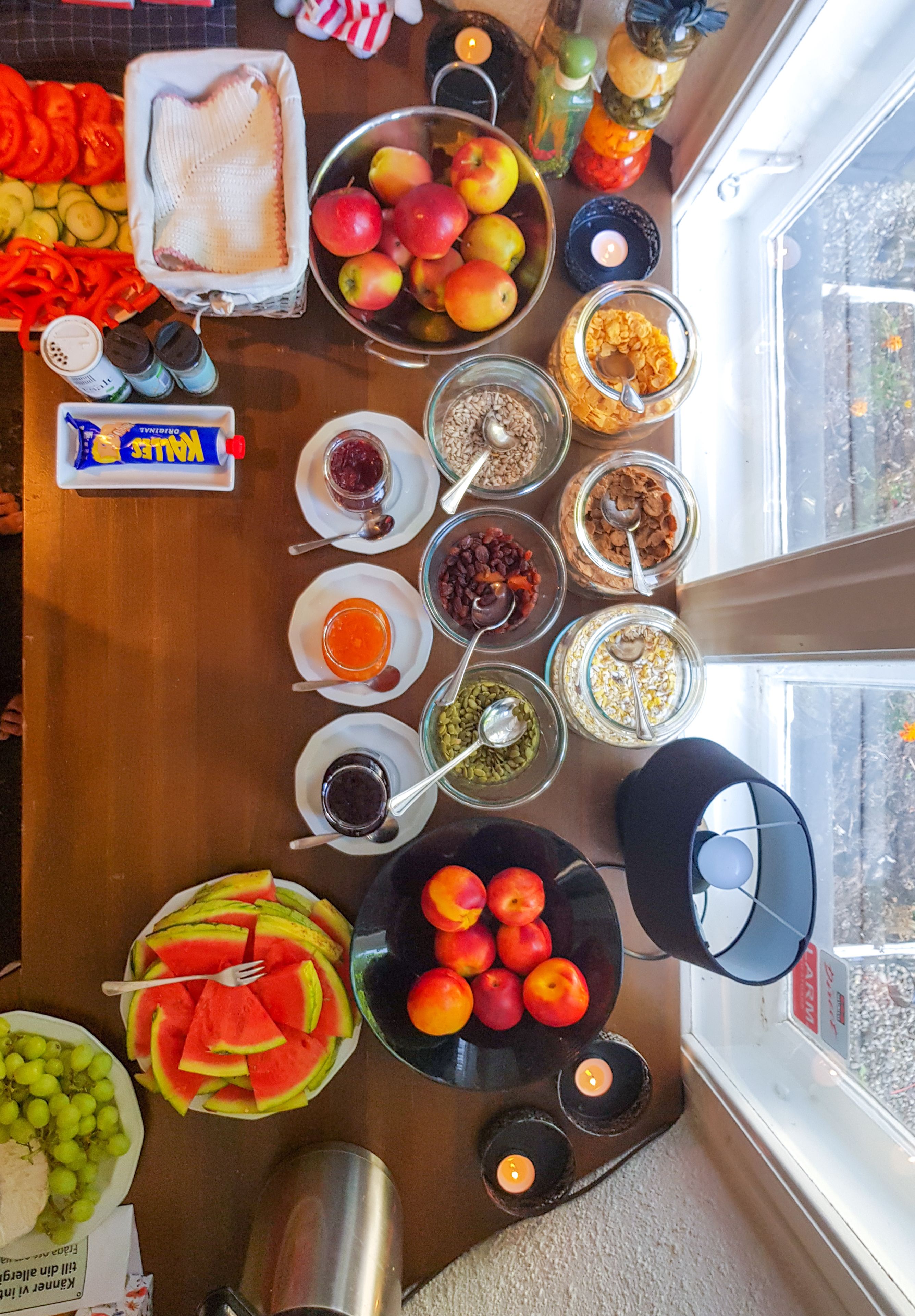 Una mesa con diversos alimentos y condimentos, como frutas, verduras y frascos con salsas.