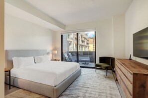 Une chambre d’hôtel moderne équipée d’un grand lit, d’un bureau, d’une chaise et d’un téléviseur.