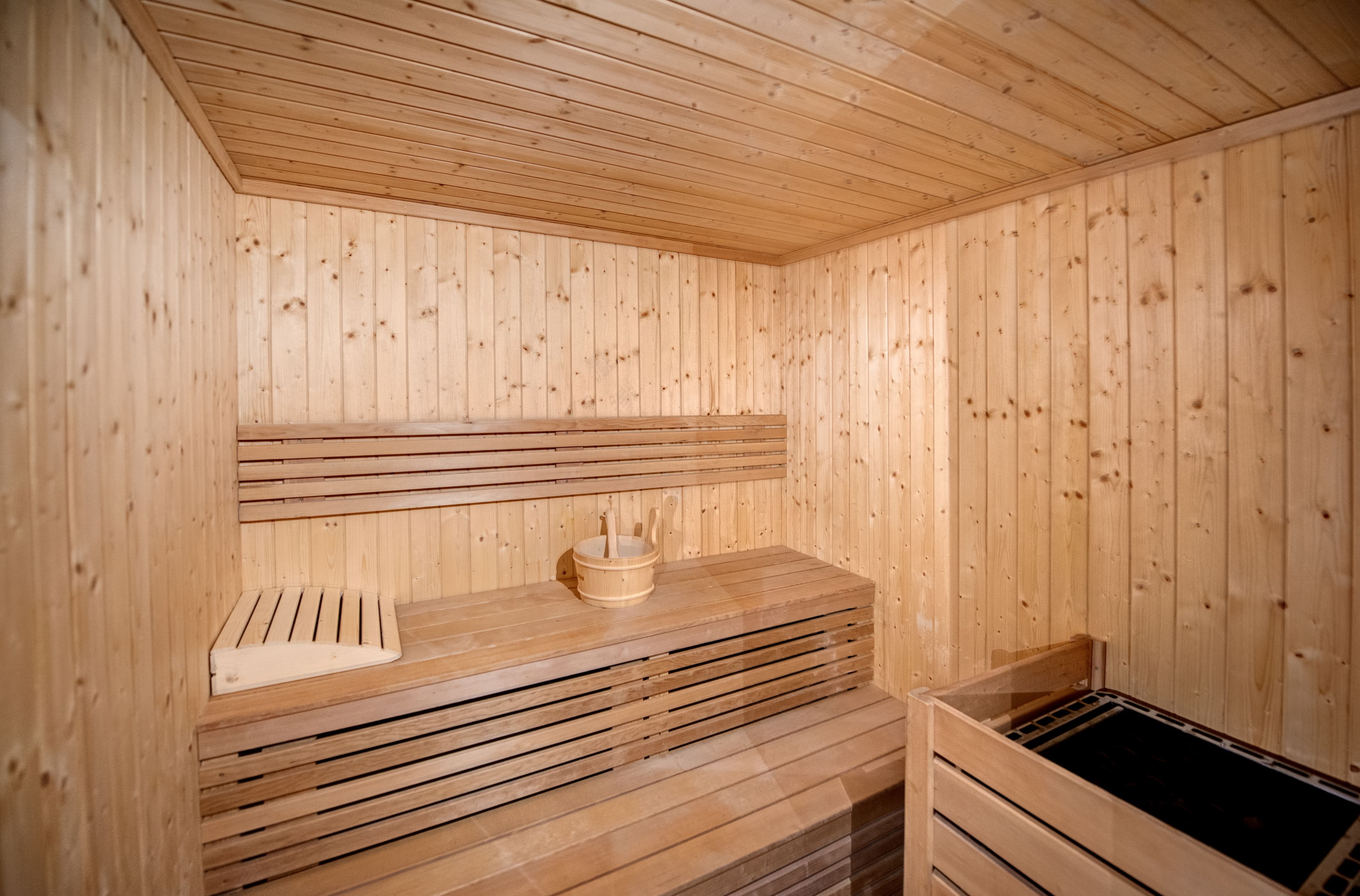 A wooden sauna with benches and a bench seat.