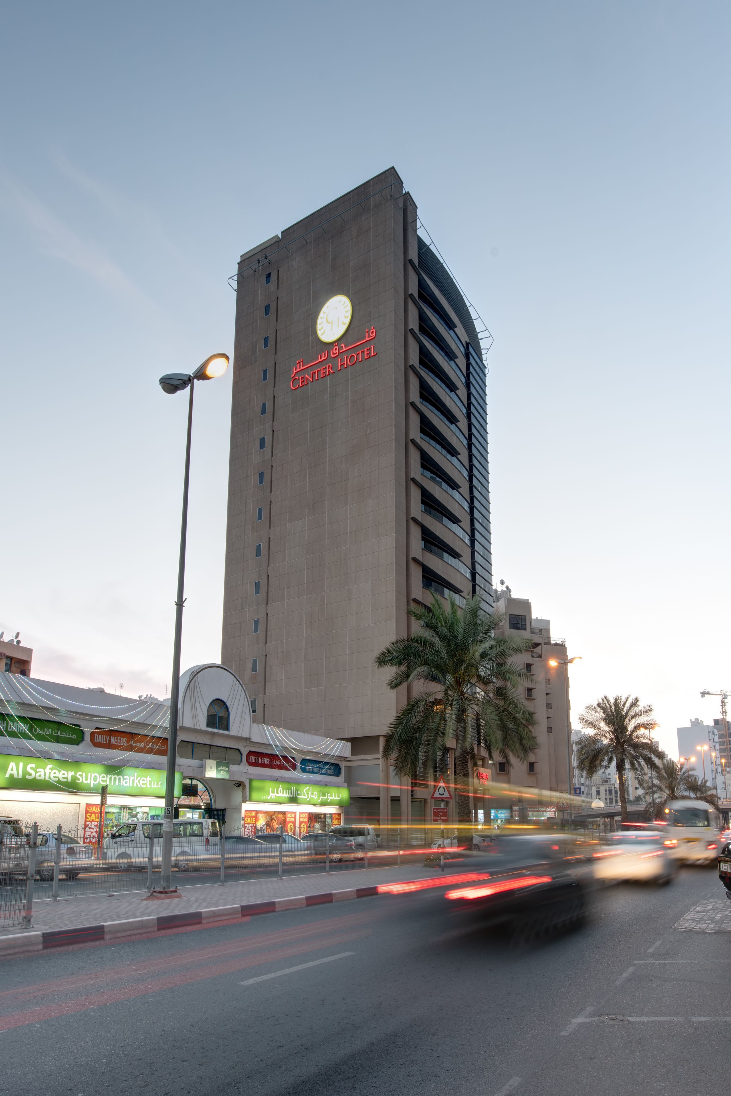 En hög byggnad med en skylt som visar texten ”Hotel Center Plaza”.