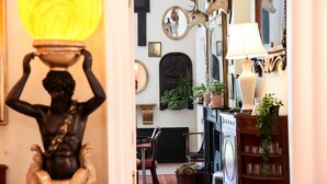 Una habitación con una estatua, espejos y chimenea.