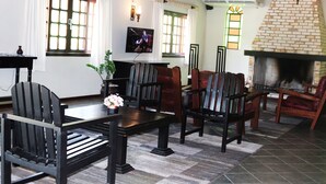 Una sala de estar acogedora con chimenea, muebles de madera y una televisión.