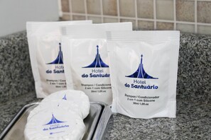 Tres botellas de champú y acondicionador del Hotel do Santuário sobre una encimera de cocina.