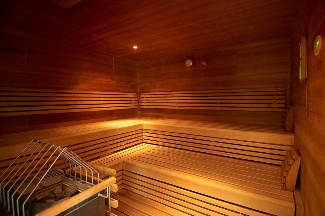 A sauna with wooden benches and a metal bench.