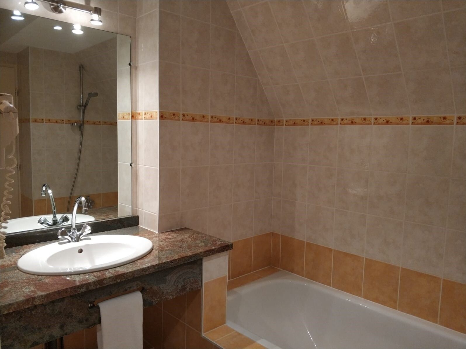Une salle de bain équipée d’un lavabo, d’un miroir, d’une douche et d’une baignoire.