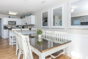 Una cocina moderna con armarios blancos, microondas y cafetera.