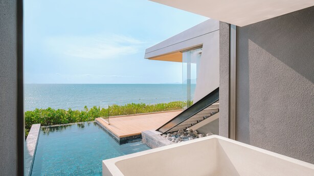 A modern infinity pool with a view of the ocean, a white bathtub, and a staircase leading to a balcony. - MASON, a member of Design Hotels (Sattahip)