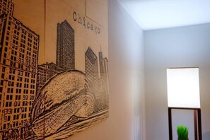 A wall with a cityscape mural labeled "Chicago" and a lamp in the corner. - The Karlov Connection - Ohare Wrigley Gateway (Chicago)