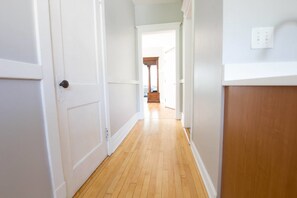 A hallway with white walls, wooden flooring, and a door on the left. - Classic Lincoln Park Charmer - 3bdr Steps to Train (Chicago)
