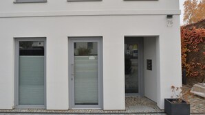 Un bâtiment moderne à deux étages, avec trois fenêtres à l’étage supérieur et deux à l’étage inférieur.