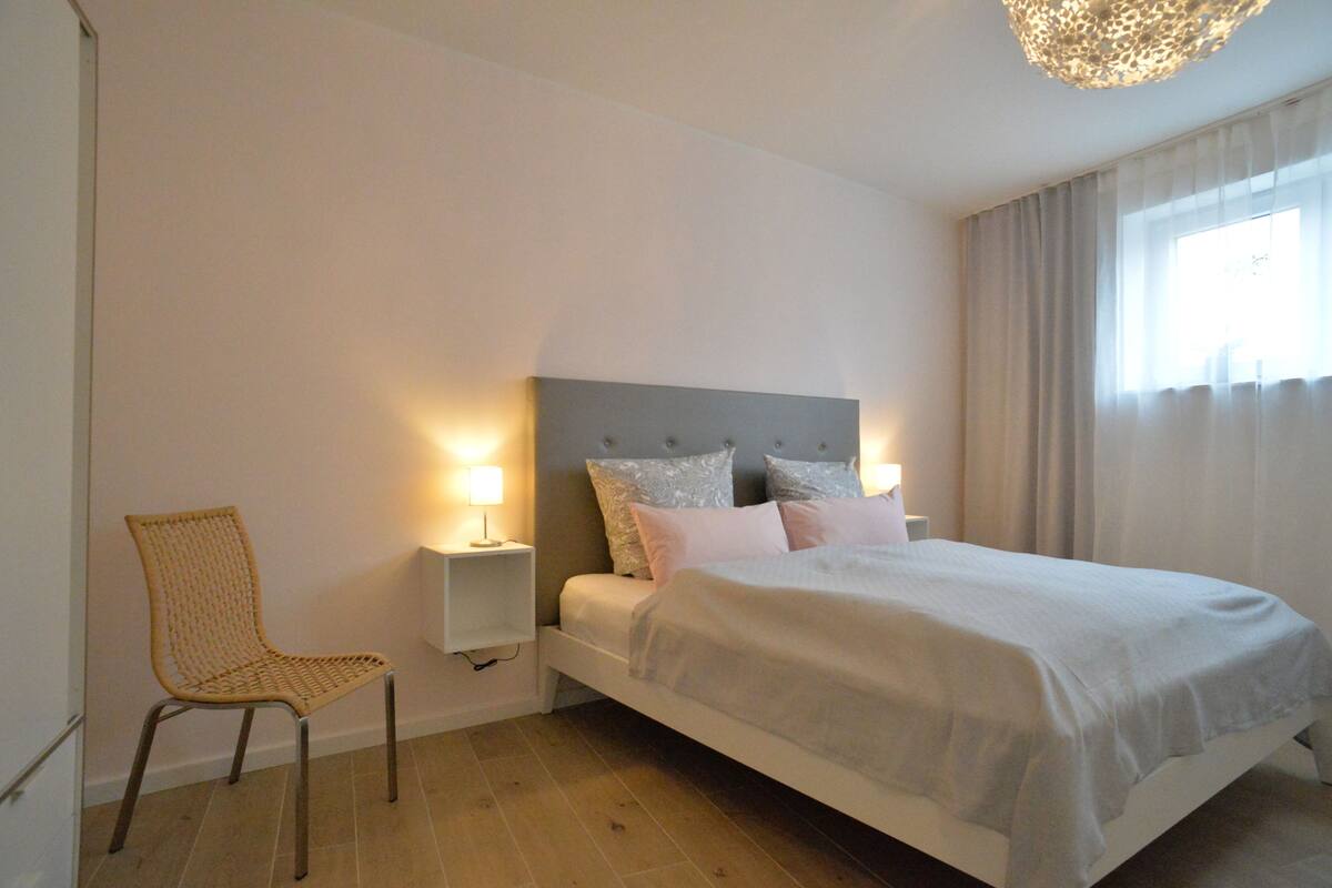 Quarto com cama, cadeira e abajures.