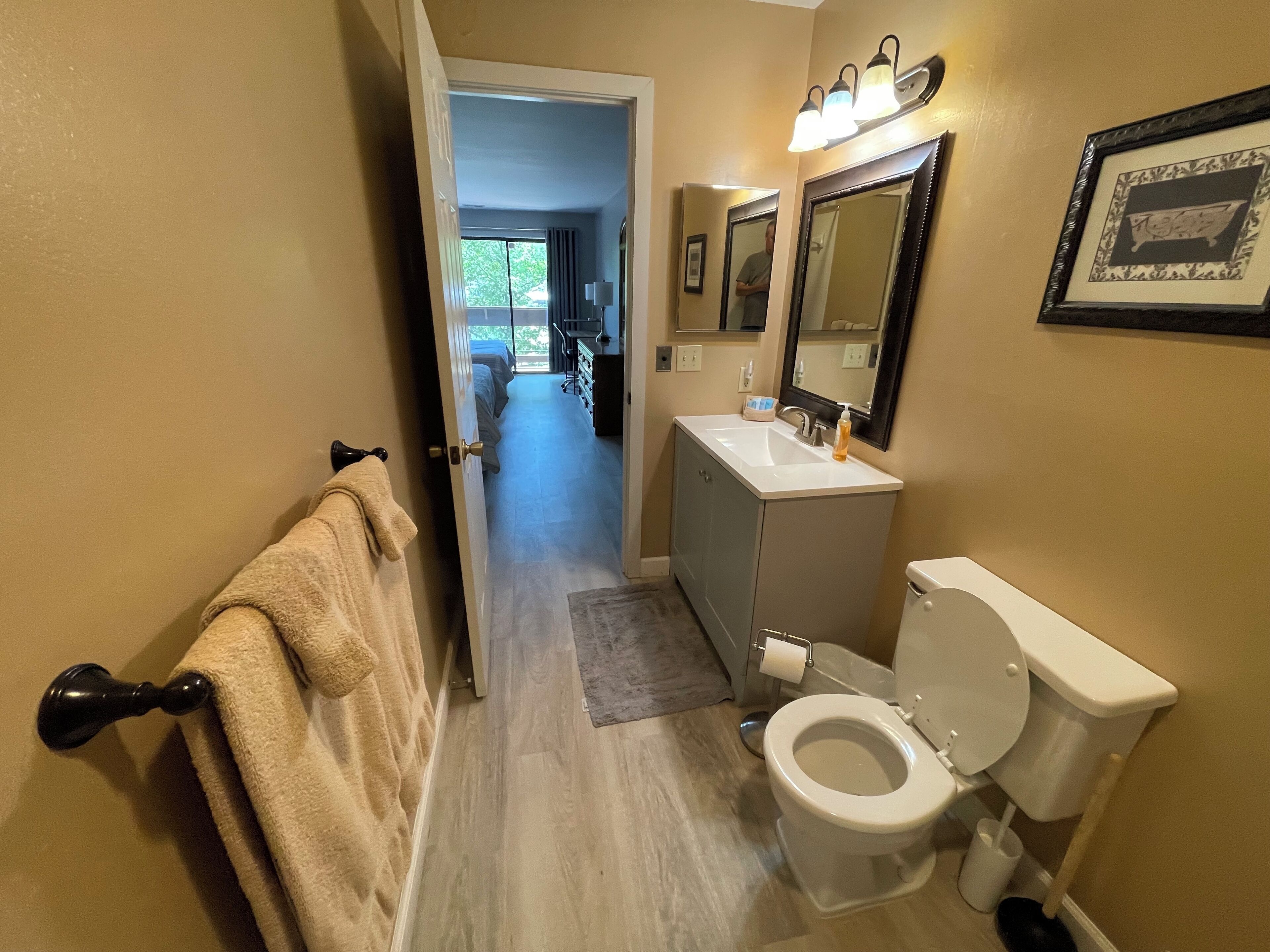 A modern bathroom with a toilet, sink, and mirrors.