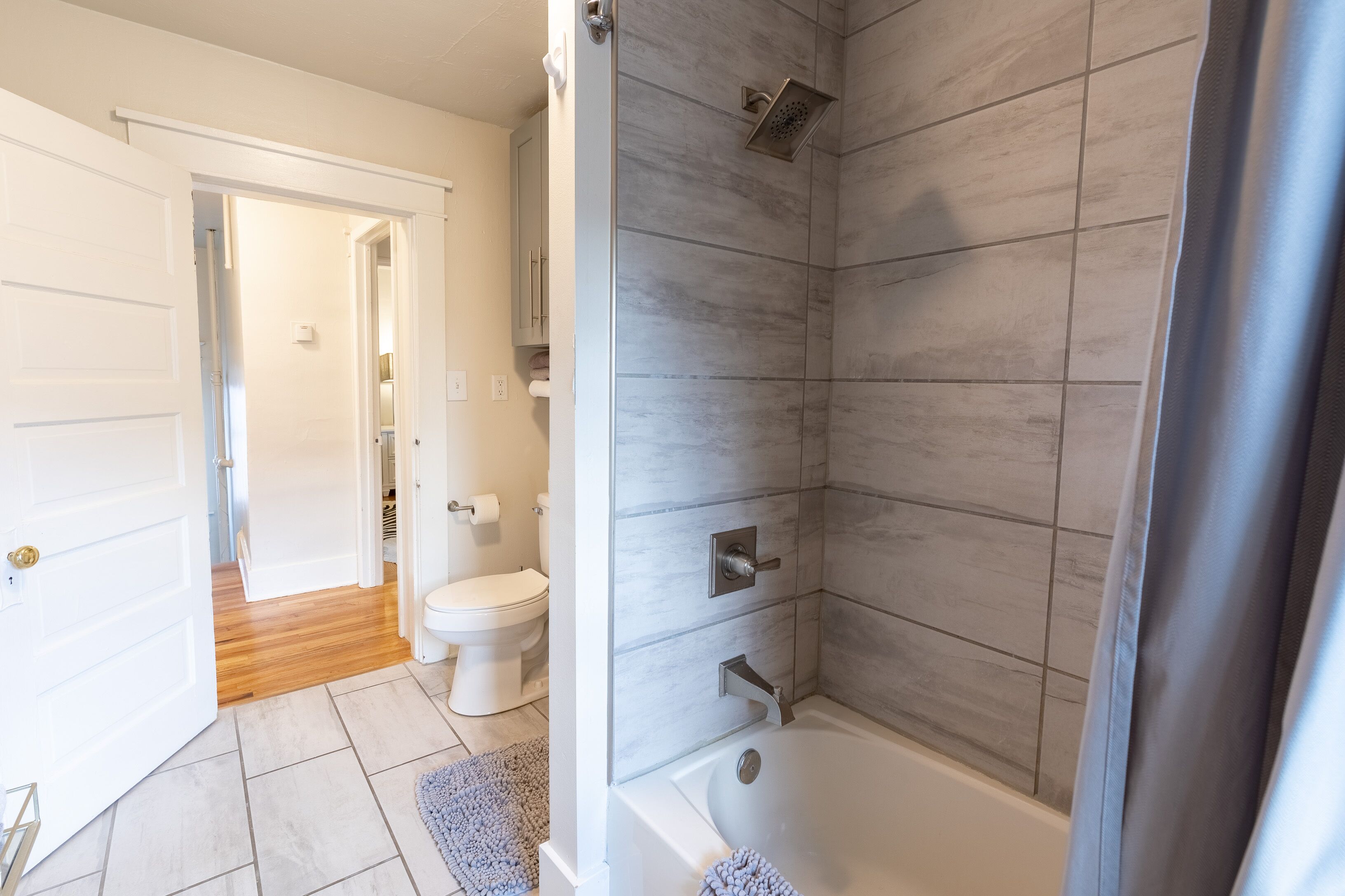 A modern bathroom with a shower, toilet, and bathtub.