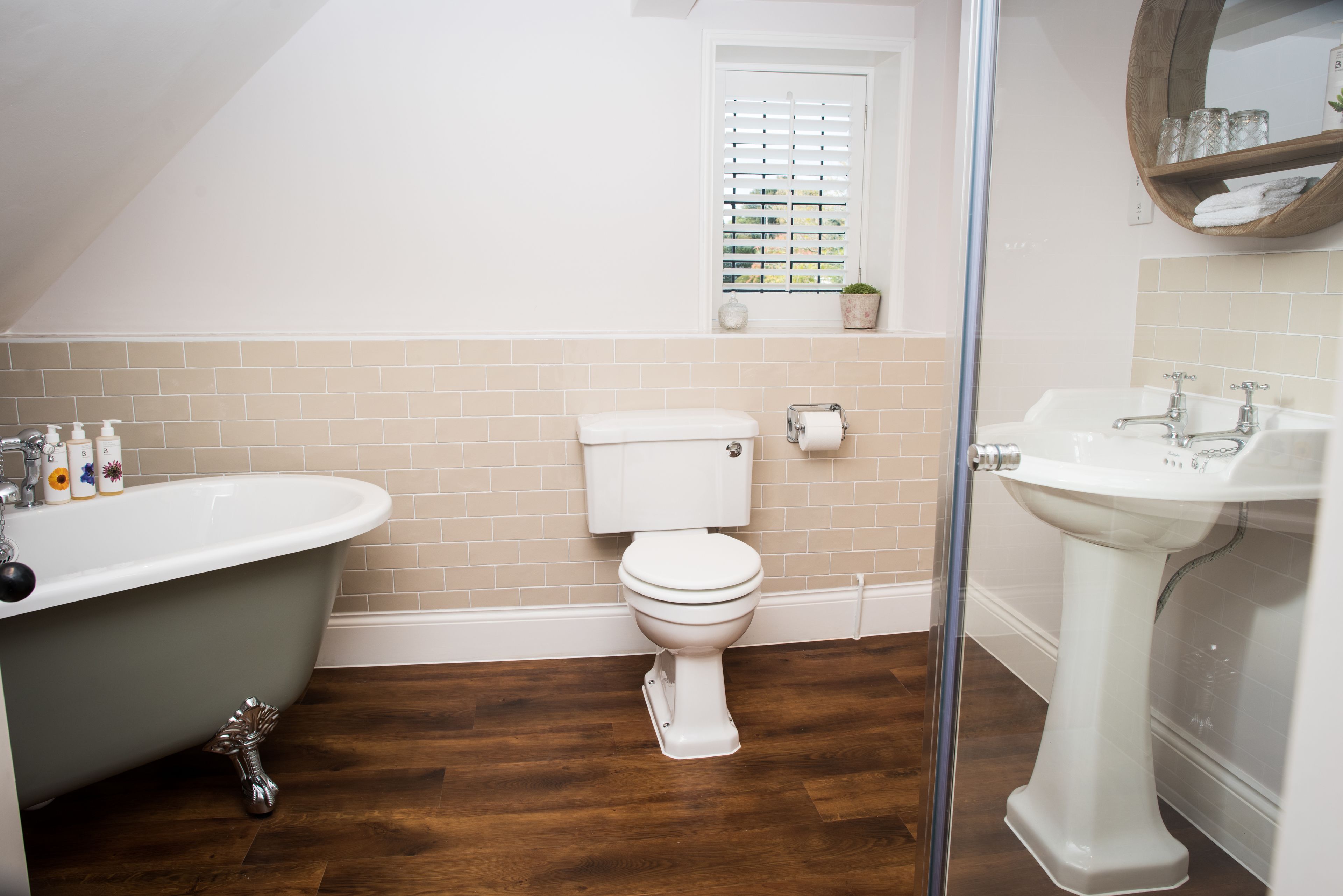 A bathroom with a freestanding bathtub, a toilet, and a pedestal sink.